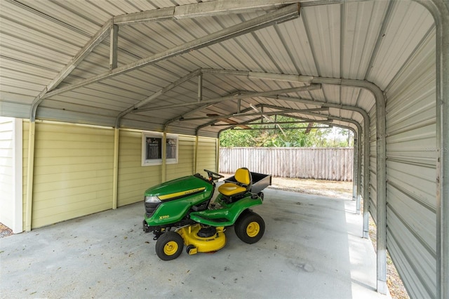 garage featuring a carport and fence