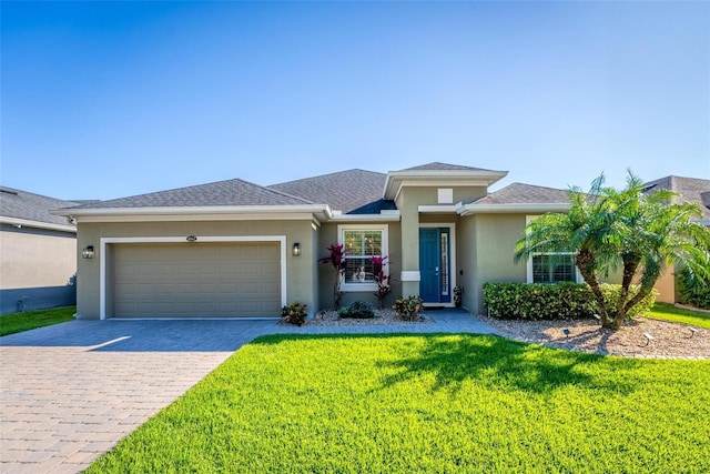 view of front of property featuring a shingled roof, a front yard, stucco siding, decorative driveway, and a garage