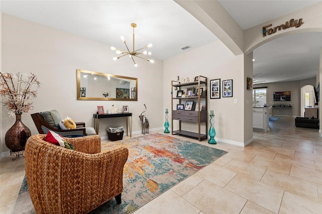 living area featuring visible vents, arched walkways, light tile patterned floors, baseboards, and a chandelier