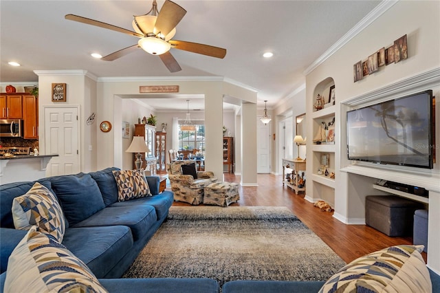 living area with wood finished floors, baseboards, recessed lighting, ceiling fan, and crown molding