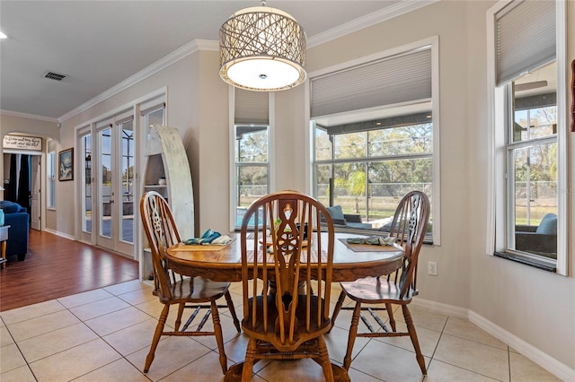 dining room with light tile patterned floors, visible vents, french doors, and ornamental molding