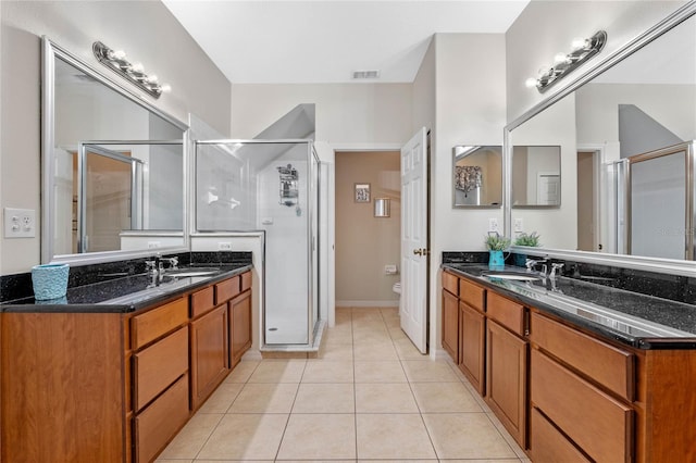 bathroom featuring two vanities, a sink, a shower stall, tile patterned floors, and toilet