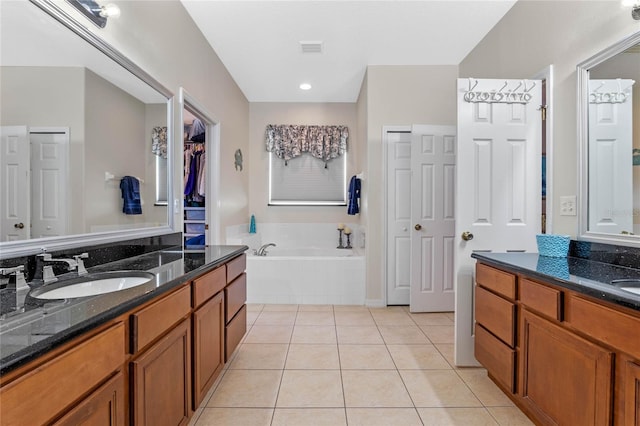 bathroom featuring visible vents, a sink, a closet, tile patterned floors, and a bath