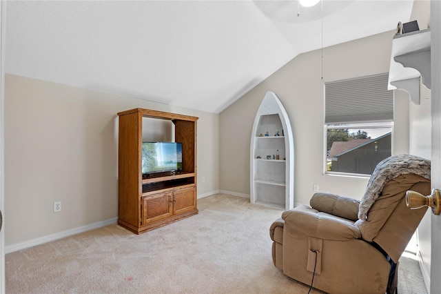 living area featuring lofted ceiling, light colored carpet, and baseboards