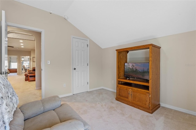 living area featuring vaulted ceiling, baseboards, and light carpet