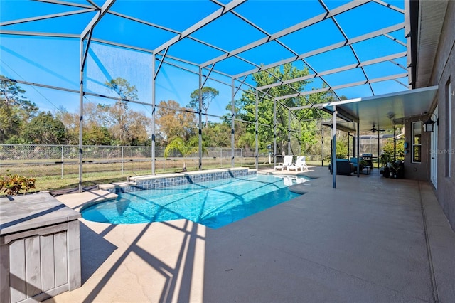 view of swimming pool featuring a ceiling fan, fence, glass enclosure, a fenced in pool, and a patio area