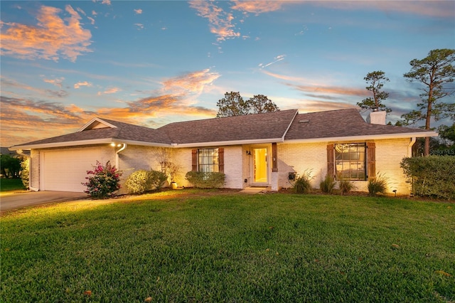 ranch-style house featuring driveway, a front lawn, a garage, brick siding, and a chimney