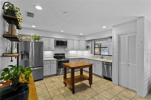 kitchen featuring visible vents, a sink, decorative backsplash, stainless steel appliances, and open shelves