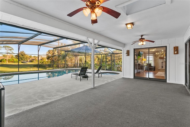 outdoor pool featuring glass enclosure, a patio area, and a ceiling fan