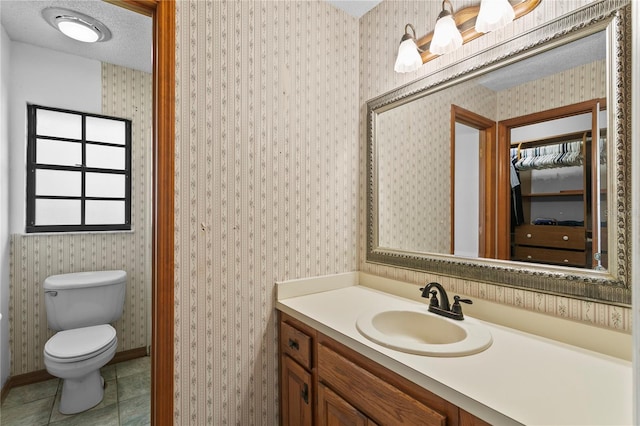 bathroom featuring wallpapered walls, tile patterned floors, toilet, and a textured ceiling