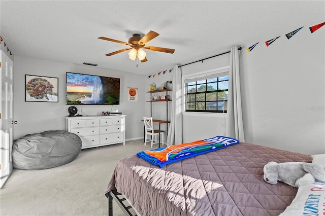 bedroom with visible vents, ceiling fan, a textured ceiling, and carpet