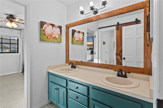 full bath with double vanity, baseboards, ceiling fan, and a sink