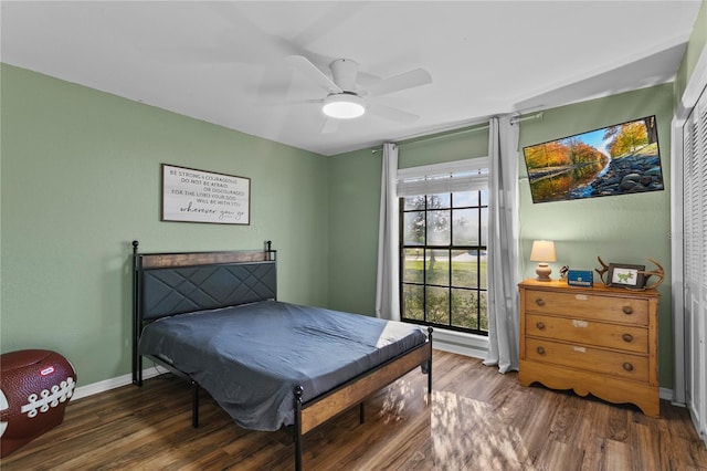 bedroom with a ceiling fan, wood finished floors, and baseboards