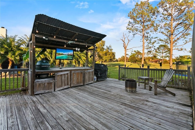 deck with area for grilling, a lawn, and an outdoor kitchen