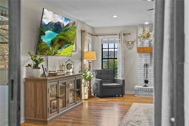 living area featuring recessed lighting, wood finished floors, and a fireplace