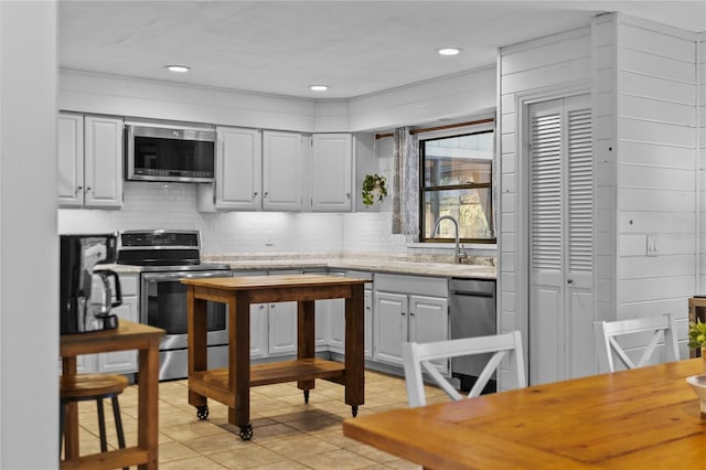 kitchen with decorative backsplash, stainless steel appliances, light countertops, and a sink