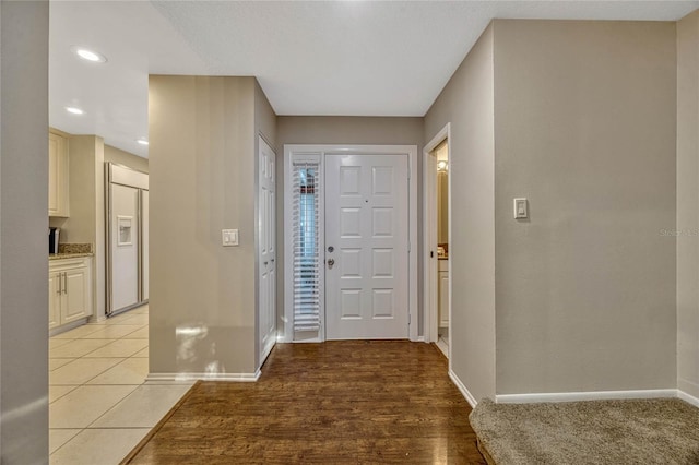 foyer entrance featuring light tile patterned flooring, recessed lighting, and baseboards