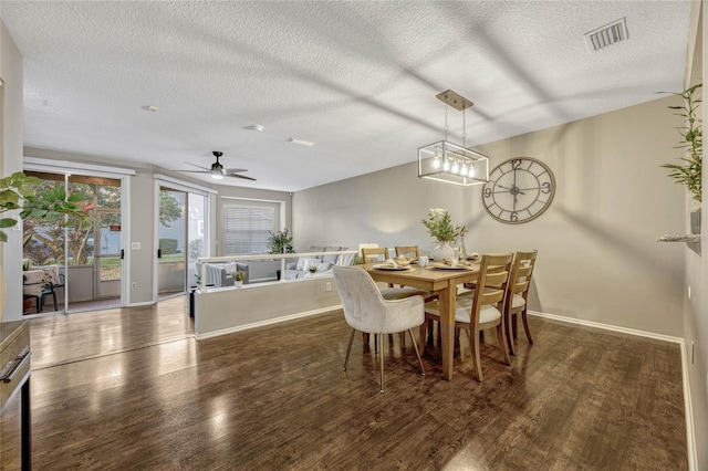 dining space featuring visible vents, baseboards, a textured ceiling, and wood finished floors