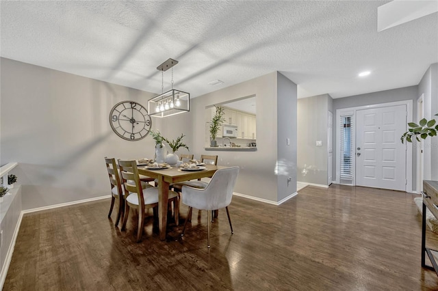 dining area featuring baseboards, a textured ceiling, and wood finished floors