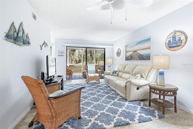 living room featuring visible vents, a ceiling fan, baseboards, and wood finished floors