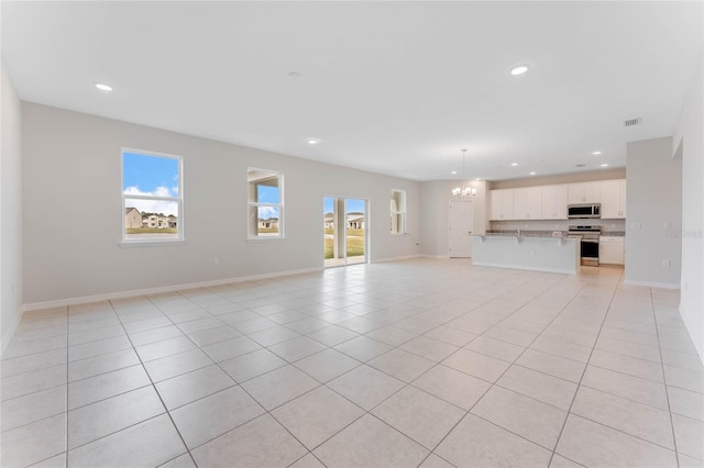 unfurnished living room with visible vents, baseboards, a chandelier, light tile patterned floors, and recessed lighting