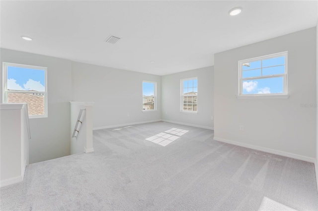 carpeted empty room featuring visible vents, recessed lighting, and baseboards