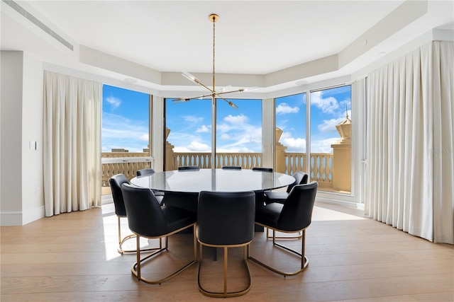 dining space with a chandelier, a wall of windows, and light wood-type flooring