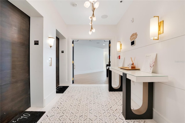 corridor featuring elevator and baseboards