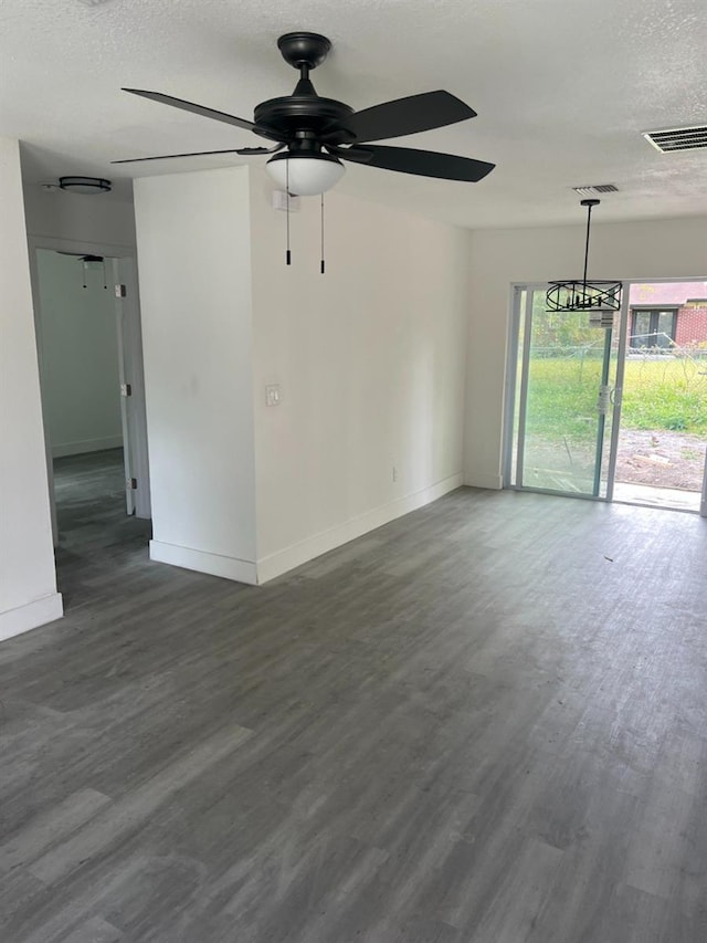 spare room with visible vents, a textured ceiling, and wood finished floors