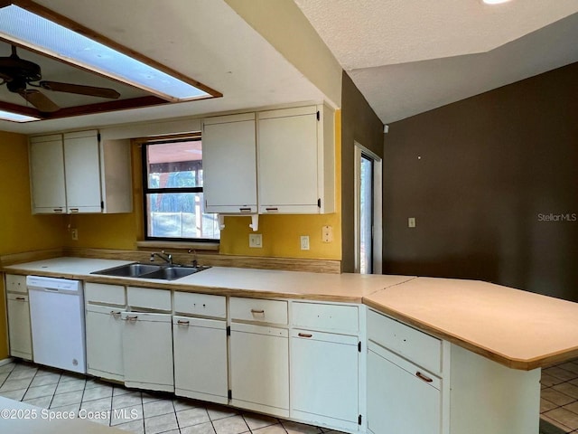 kitchen featuring a sink, a peninsula, light countertops, light tile patterned floors, and dishwasher