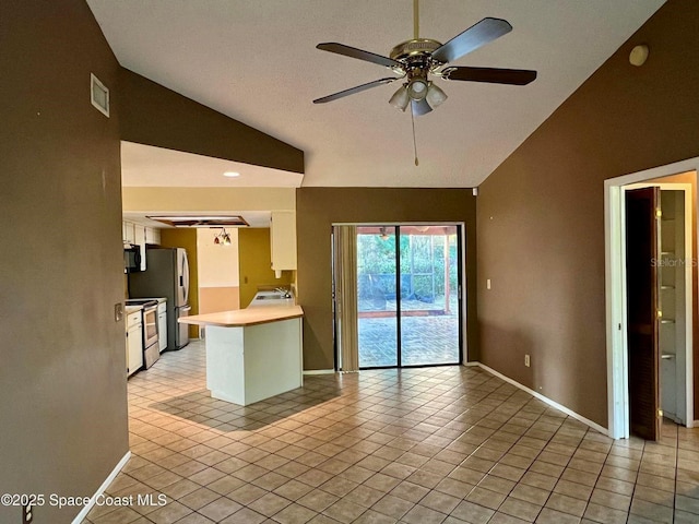 kitchen featuring light tile patterned floors, white cabinetry, light countertops, and vaulted ceiling