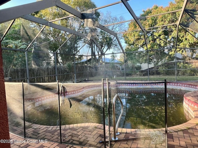 view of pool featuring glass enclosure, fence private yard, and a fenced in pool