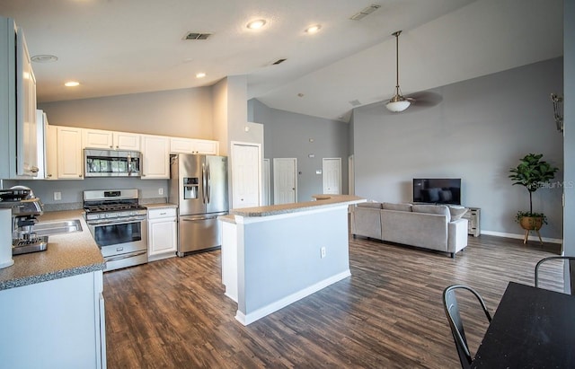 kitchen featuring visible vents, dark wood finished floors, appliances with stainless steel finishes, white cabinetry, and a center island