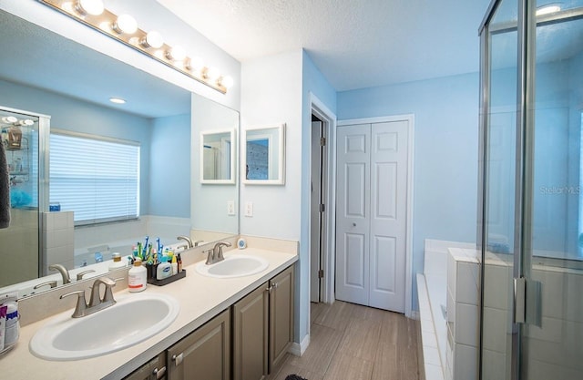 bathroom featuring a sink, a garden tub, a stall shower, and double vanity