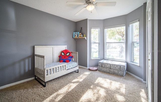 carpeted bedroom featuring baseboards and a ceiling fan