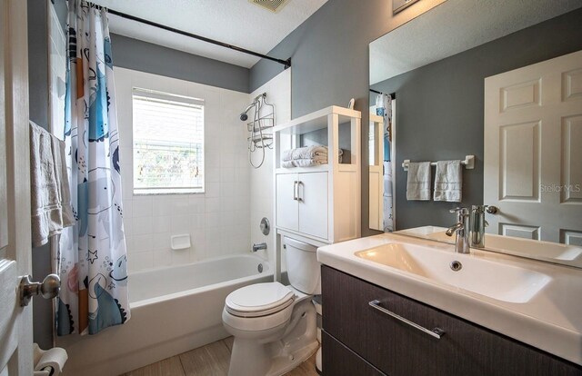 full bathroom featuring visible vents, toilet, shower / tub combo with curtain, a textured ceiling, and vanity