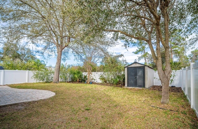 view of yard with a fenced backyard, a patio area, an outdoor structure, and a shed