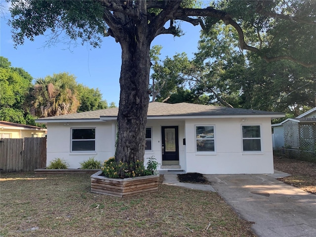 single story home with fence, driveway, roof with shingles, and stucco siding