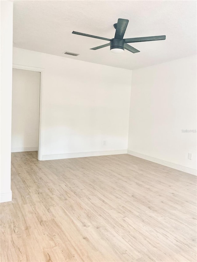 spare room featuring light wood-style floors, ceiling fan, and baseboards