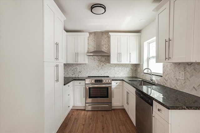 kitchen featuring wall chimney exhaust hood, stainless steel appliances, a sink, dark wood finished floors, and white cabinetry