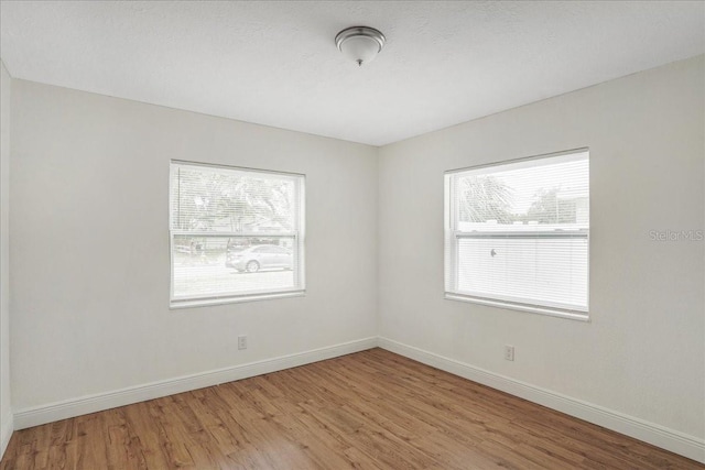 spare room featuring wood finished floors and baseboards