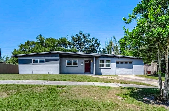 view of front facade with driveway, a front lawn, an attached garage, and fence