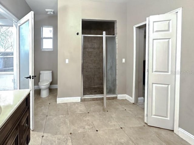 full bathroom featuring toilet, a stall shower, vanity, and baseboards