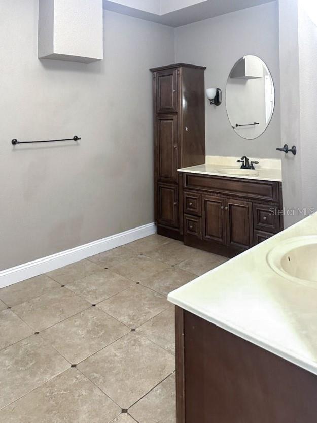 bathroom featuring baseboards, vanity, and tile patterned flooring