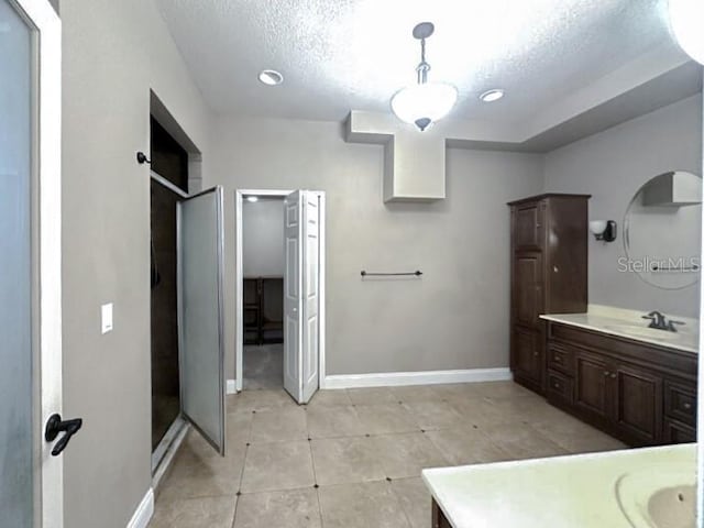 bathroom featuring a stall shower, vanity, and baseboards