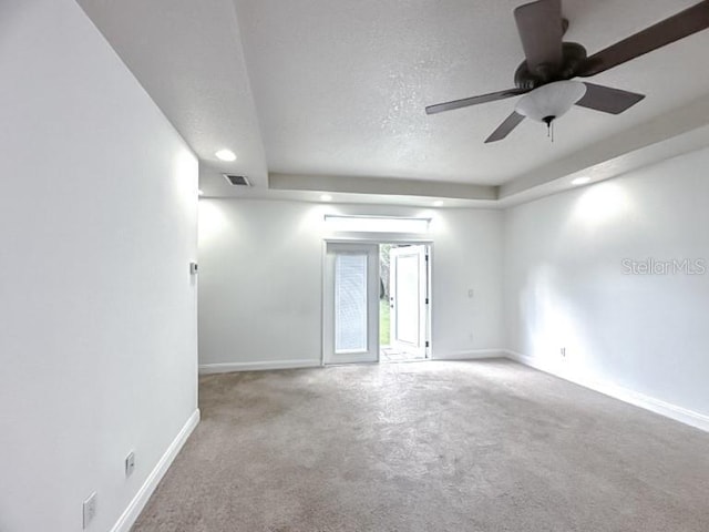 carpeted spare room with a ceiling fan, baseboards, and visible vents