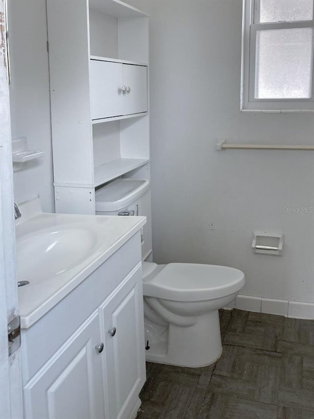 bathroom with vanity, toilet, and baseboards