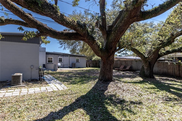 view of yard with a patio, a fenced backyard, and central AC