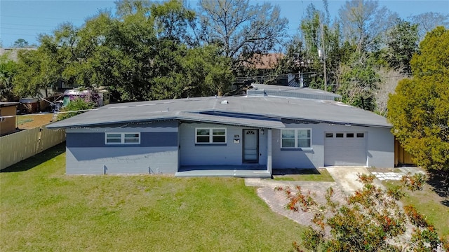 view of front of house with an attached garage, covered porch, a front lawn, and fence