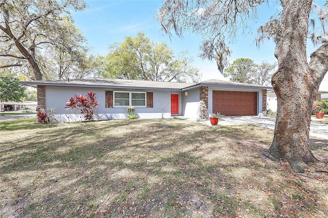 view of front facade with stucco siding, stone siding, concrete driveway, a front yard, and a garage